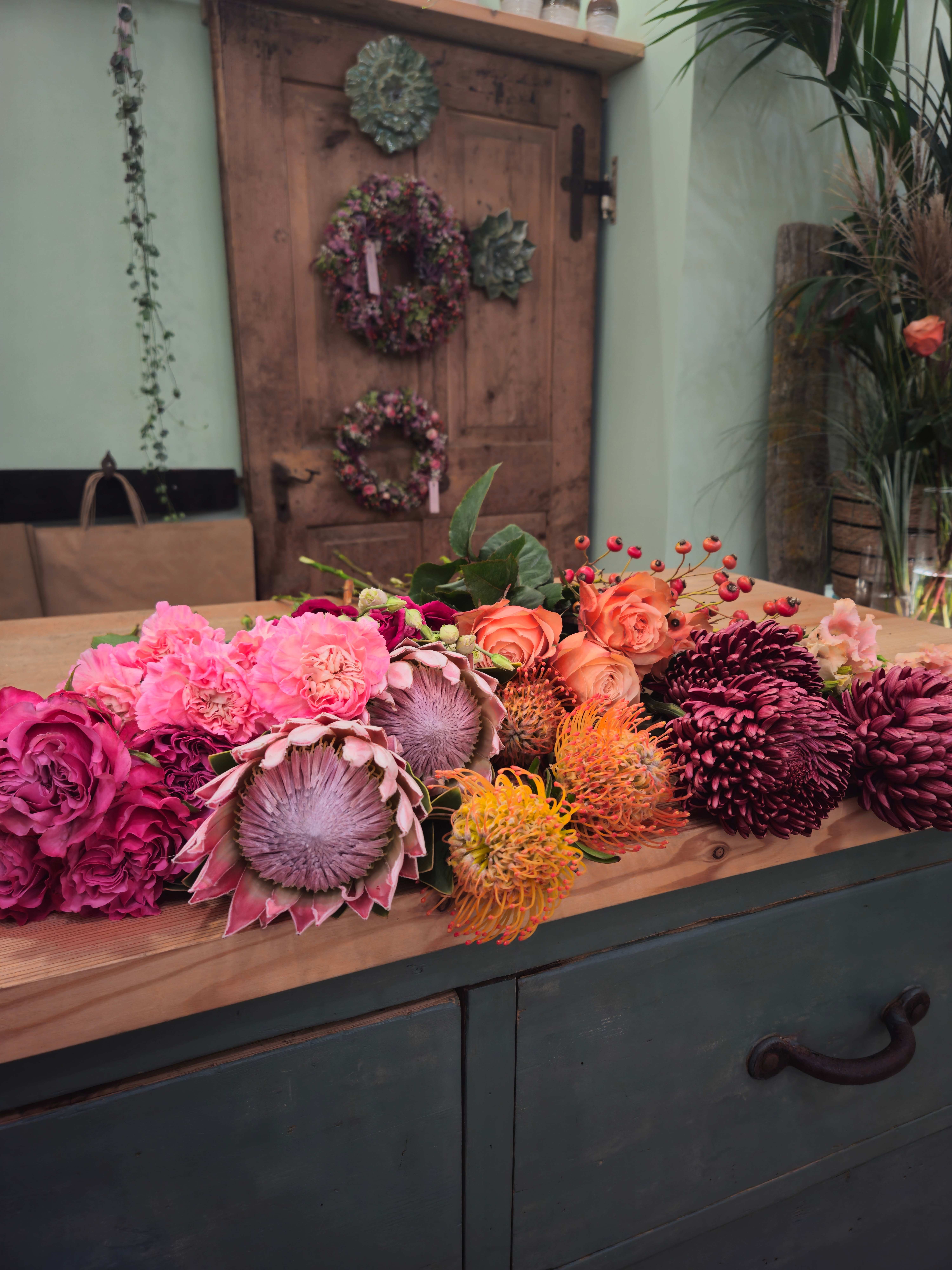 Fiori recisi disposti sul bancone in legno dell’atelier